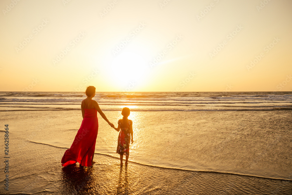 Mother in long dress and daughter on sunset. happy mothers Day