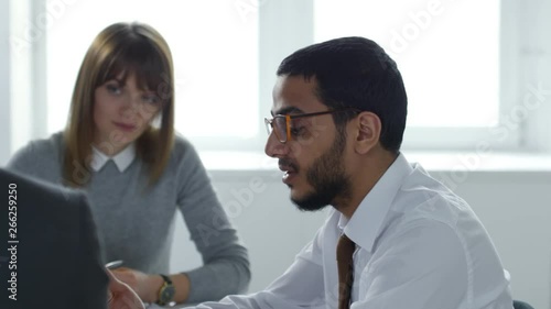Wallpaper Mural Middle eastern businessman in eyeglasses and formal shirt and tie talking to male and female employees during office meeting Torontodigital.ca