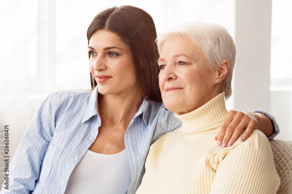 Family values. Daughter hugging mother and looking aside Family values. Daughter hugging mother and looking aside