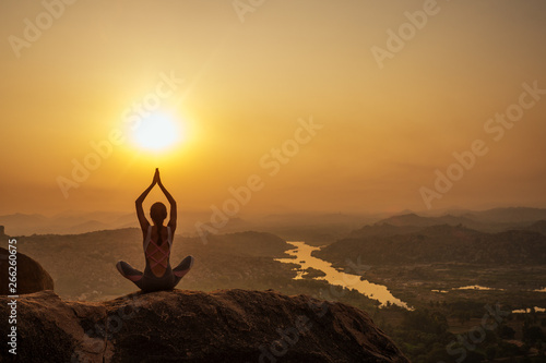 Yoga in Hampi temple copyspase at sunset.travel vacation copy spase lady with stylish jumpsuit photo