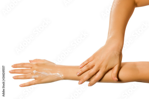 closeup of female hands applying hand cream on white background