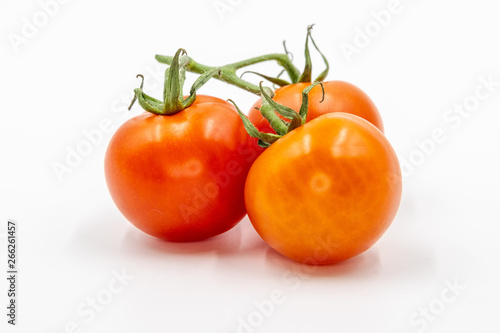 Three red tomatoes with branch