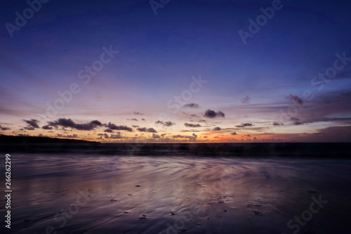 the beauty of Jimbaran beach in Bali Indonesia at dusk with the sun disappearing