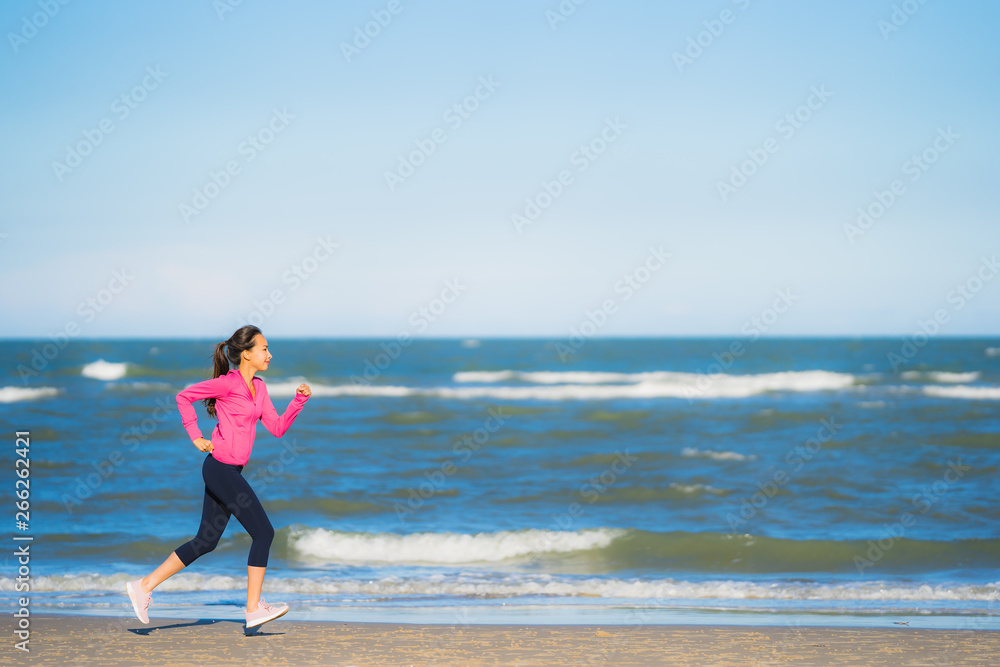 Portrait beautiful young asian woman running or exercise on the tropica nature landscape of beach Portrait beautiful young asian woman running or exercise on the tropica nature landscape of beach