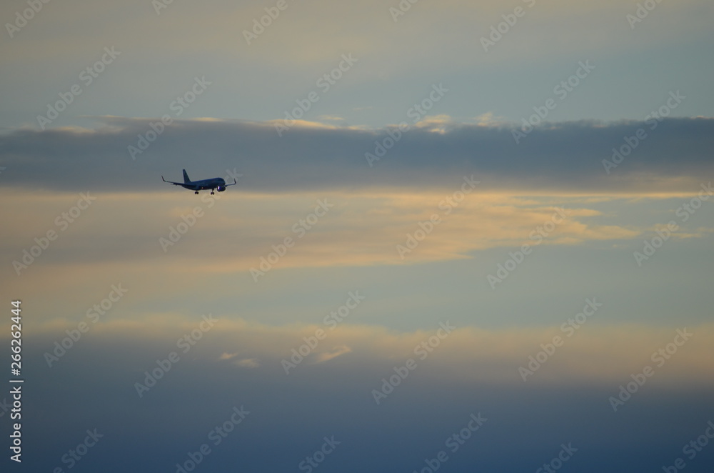 Cloudy sky with an approaching aircraft over the coast at Glenelg South Australia