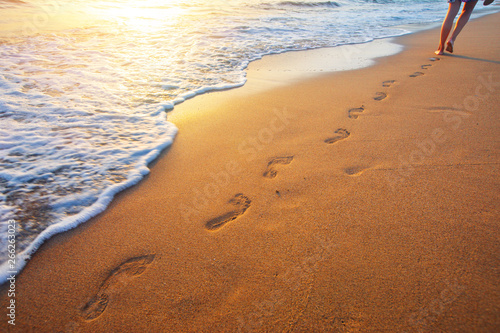 Fototapeta Naklejka Na Ścianę i Meble -  beach, wave and footprints at sunset time