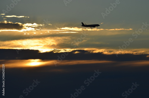 Rich ocean beach sunset behind aircraft on approach to Glenelg South Australia