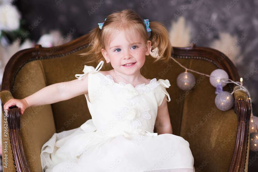 Cute kid girl 2 3 year old wearing stylish dress sitting in chair