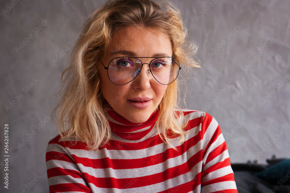 Fototapeta premium Portrait of beautiful young European woman with glasses. Charming blonde