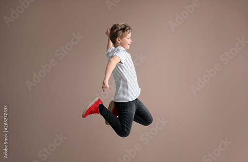 Jumping little boy on color...