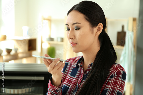 Young Asian woman with mobi...