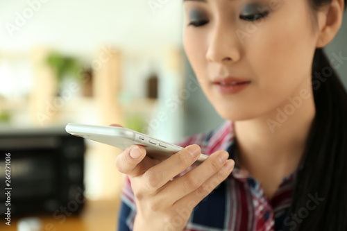 Young Asian woman with mobi...