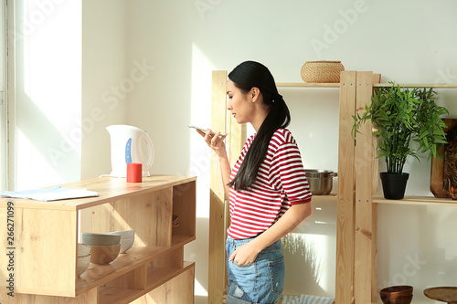 Young Asian woman with mobi...