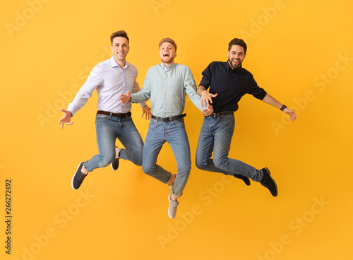Jumping young men on color ...