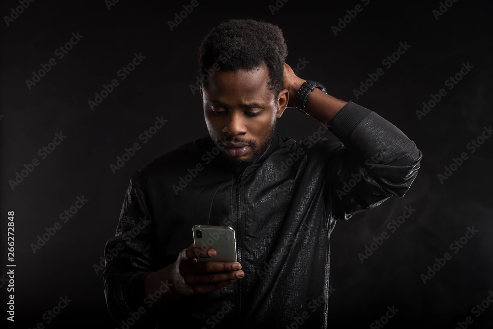 Black man holding mobile phone in dark Black man holding mobile phone in dark