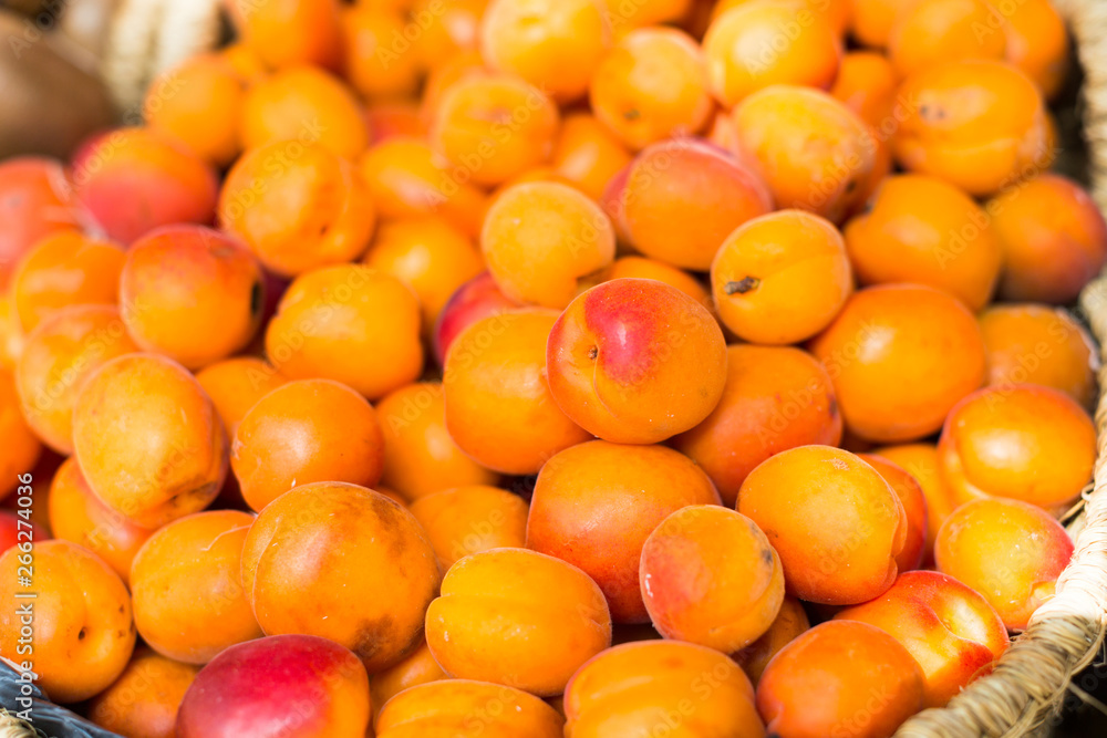 appetizing apricots in wicker baskets on counter in market