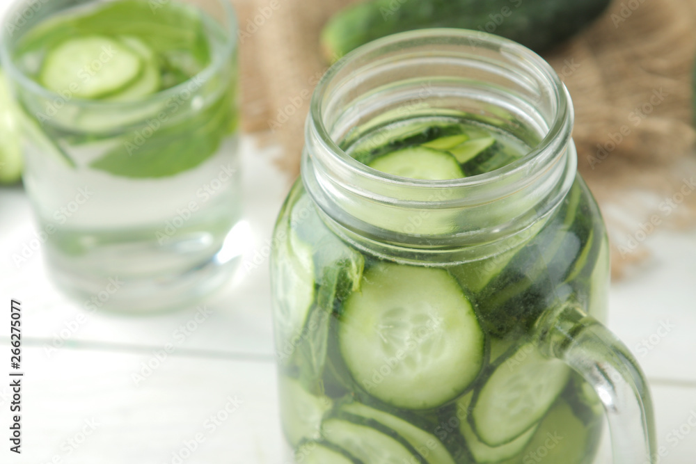 water with cucumber. Refreshing diet water with cucumber in a glass cup on a light background. detox drink concept. summer refreshing drink.