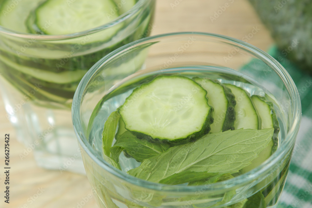 water with cucumber. Refreshing diet water with cucumber and mint in a glass beaker on a wooden background. detox drink concept. summer refreshing drink. water with cucumber. Refreshing diet water with cucumber and mint in a glass beaker on a wooden background. detox drink concept. summer refreshing drink.