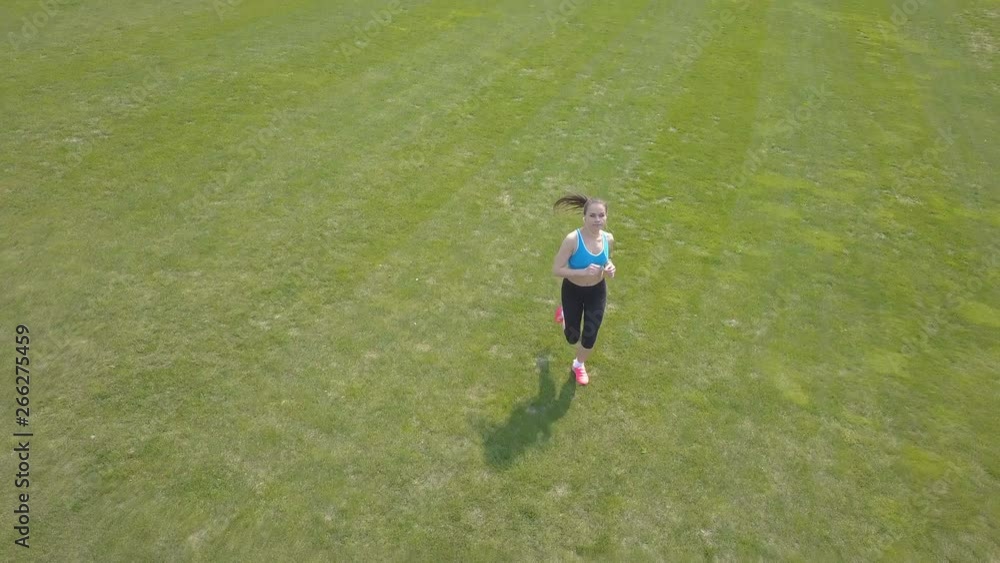4K. Healthy aerial team. Woman fitness runner run on green field. Low height 4K. Healthy aerial team. Woman fitness runner run on green field. Low height