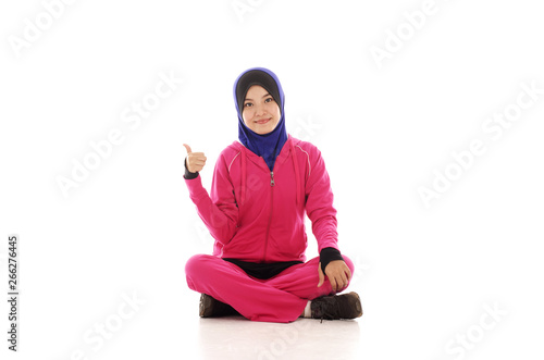 Young fitness muslimah showing thumbs up isolated on white photo