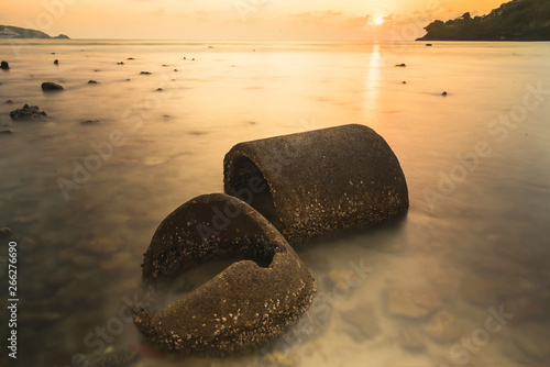 The ruins Cement pipe on the sea in sunset time.Beautiful seascape.Thailand.