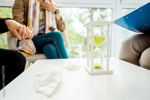 Couple sitting with psychologist during the mental therapy, cropped image with no face