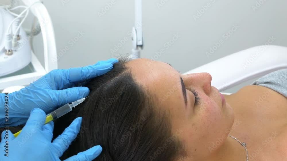 Professional beautician making head injection in a female skin. A woman gets beauty facial cosmetology procedure. Hair care injection Professional beautician making head injection in a female skin. A woman gets beauty facial cosmetology procedure. Hair care injection