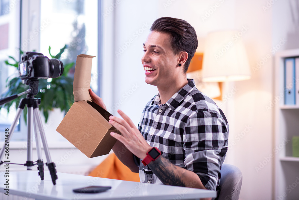Cheerful good-looking man with shaved brows having red electronic watch Cheerful good-looking man with shaved brows having red electronic watch