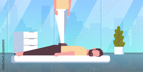 masseuse standing on patient's back doing healing treatment guy relaxing lying on table man having massage spa salon manual therapy concept modern hospital cabinet interior horizontal
