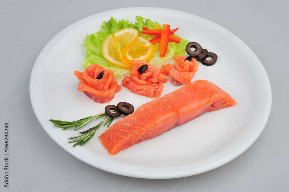 Fresh salmon decorative roses fillets, with lemon, olives on the plate. Isolated on a gray background