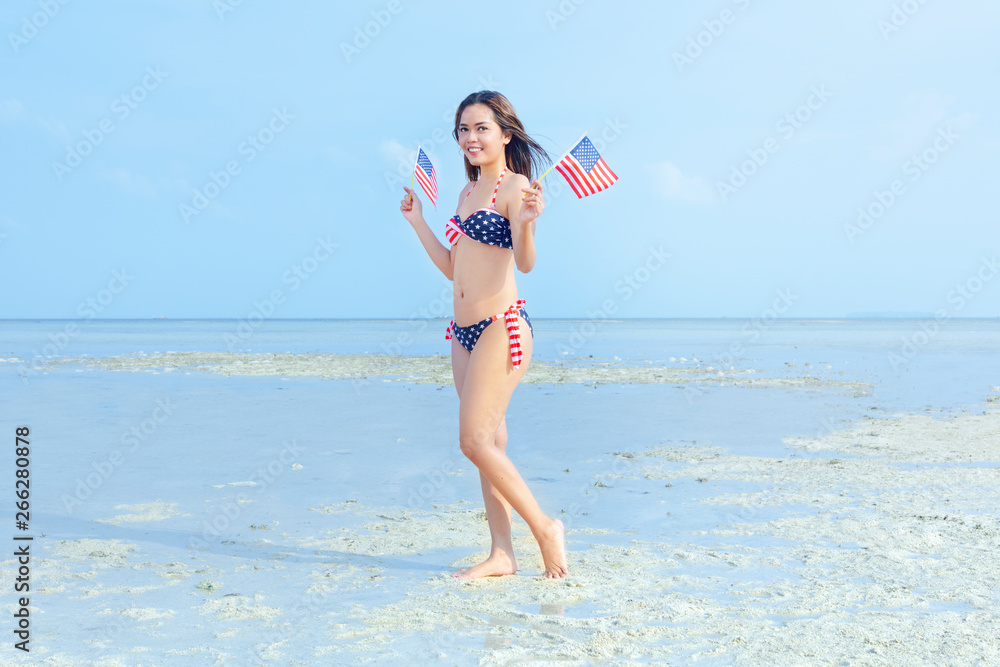 Asian sexy girl in bikini of american flag holding a little american flag  on her hands on the beach foto de Stock | Adobe Stock