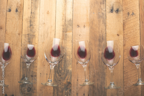 Red wine in transparent wine glasses on a wooden background. Bojole nouveau, wine bar, winery, winemaking, wine tasting concept, Flat lay photo