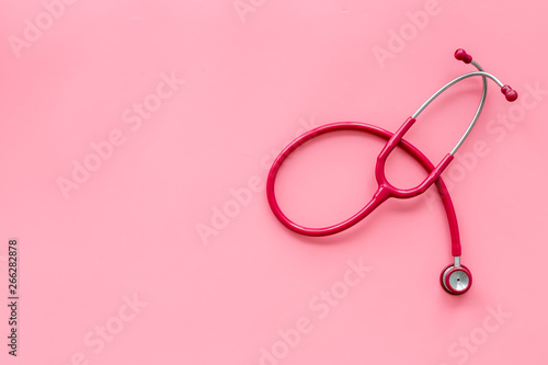 Stethoscope for family doctor set on pink background top view space for text