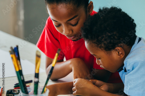 Foto Closeup of elementary African American kids creatively drawing and painting with