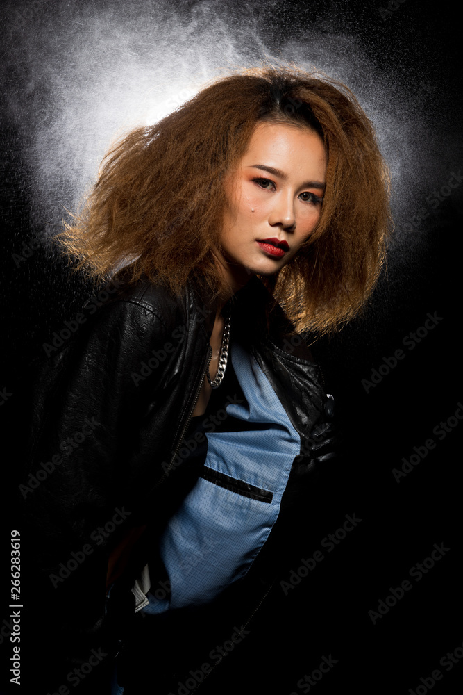 Fashion Asian Woman Tan skin Afro fu hair eyes beautiful make up black bra jacket silver necklace posing, Studio Lighting Dark Background back rim light with steam smoke effect