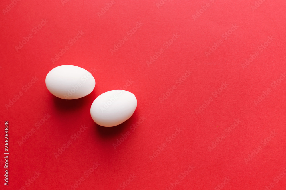 White eggs on bright red background. Top view. Place for text White eggs on bright red background. Top view. Place for text