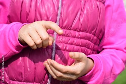 girl with pink vest pointing her finger at an invisible screen