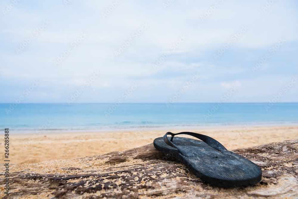 Beach slippers on a sandy beach in Phuket, Thailand.