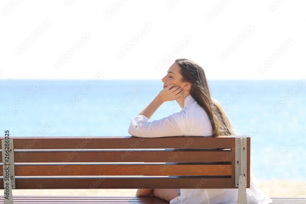 Woman relaxing sitting on a bench on the beach Woman relaxing sitting on a bench on the beach