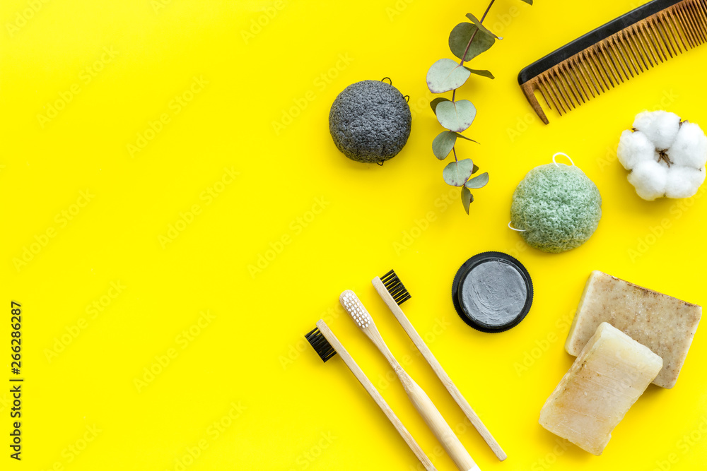 Eco materials concept with bamboo tooth brush and toothpaste with bamboo carbon on yellow background top view copy space Eco materials concept with bamboo tooth brush and toothpaste with bamboo carbon on yellow background top view copy space