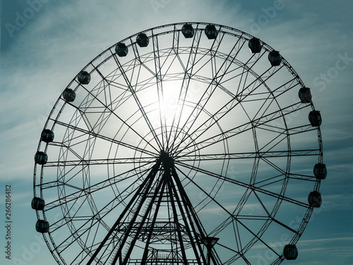 Silhouette of observation ferris wheel in amusement park at sunset sky background