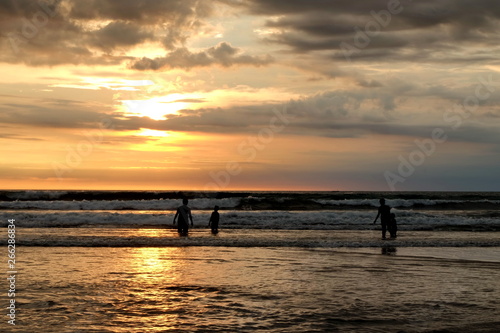 tourists while enjoying the sunset on Kuta beach, with an exciting atmosphere, the color of the sky is golden and the weather is sunny, so visitors are very comfortable to linger © onyengradar