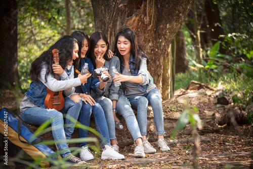 Asian group girls, they stop drinking water and relaxing during hiking.