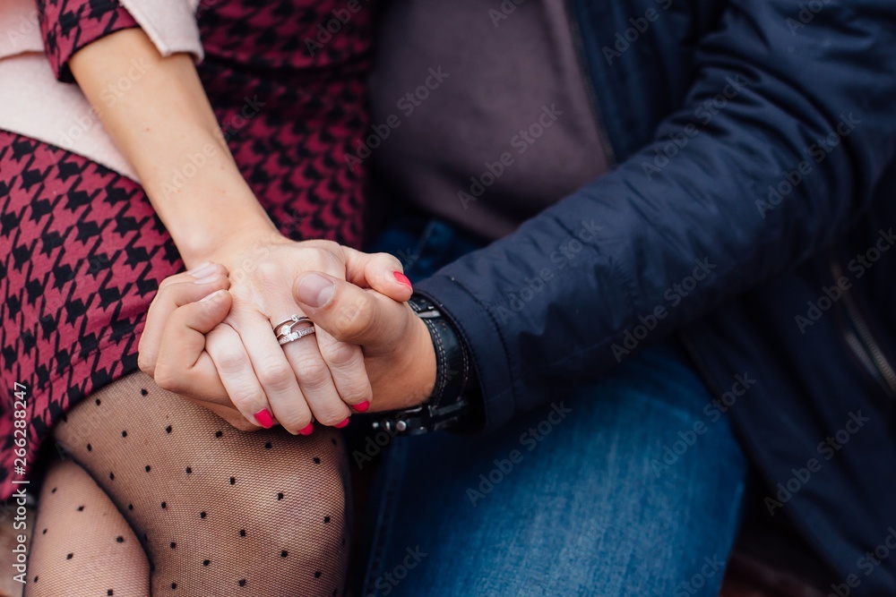 Hands of inloved couple holding each other.