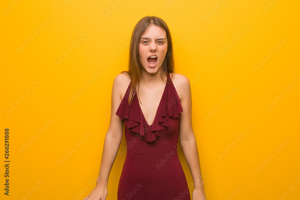 Obraz premium Young elegant woman wearing a dress screaming very angry and aggressive