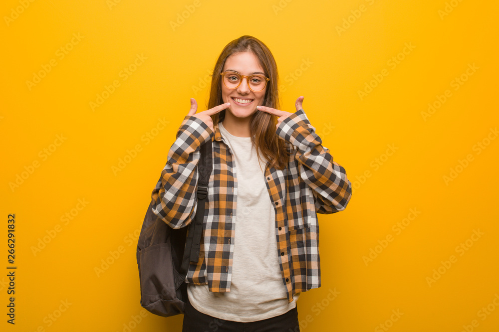 Young student woman smiles, pointing mouth Young student woman smiles, pointing mouth
