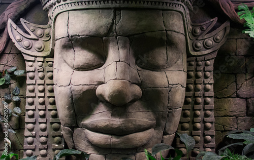 stone sculpture of a human face in the jungle