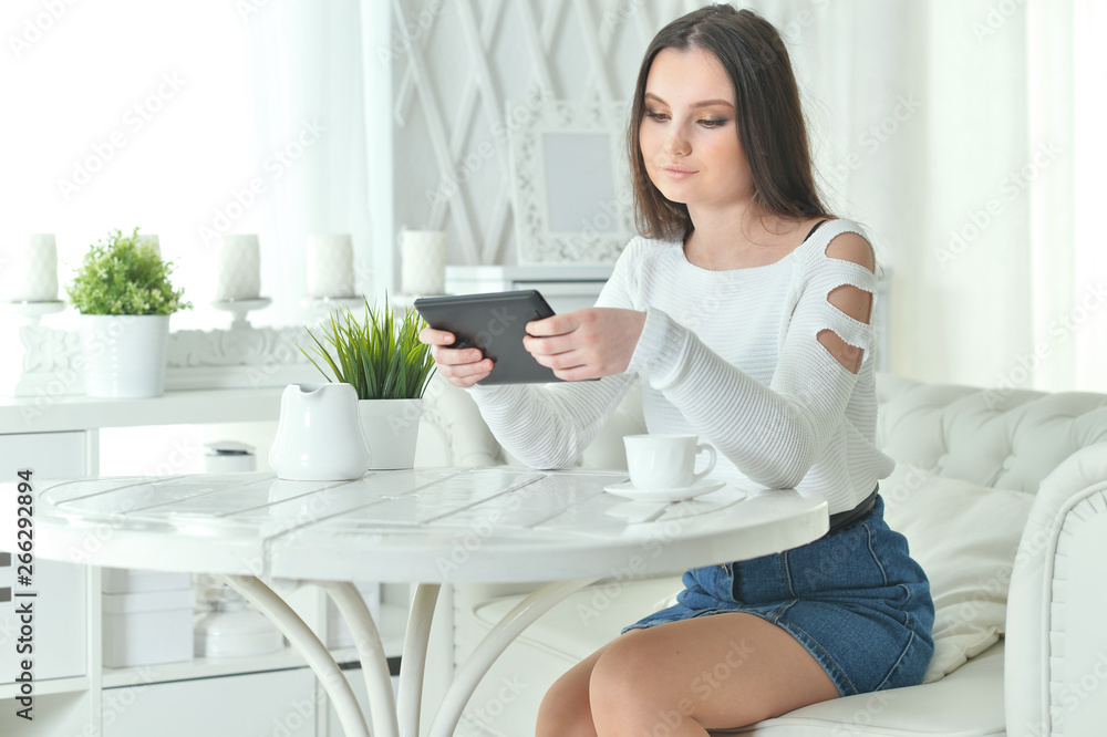Portrait of young woman using digital tablet at home Portrait of young woman using digital tablet at home