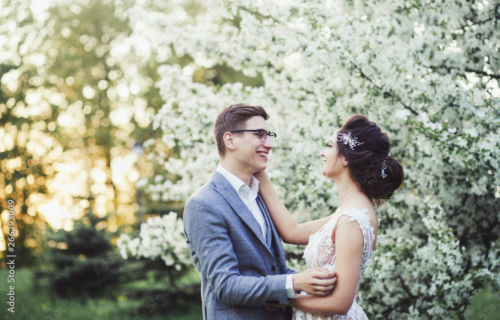 Fototapeta premium happy bride and groom in spring Park at sunset