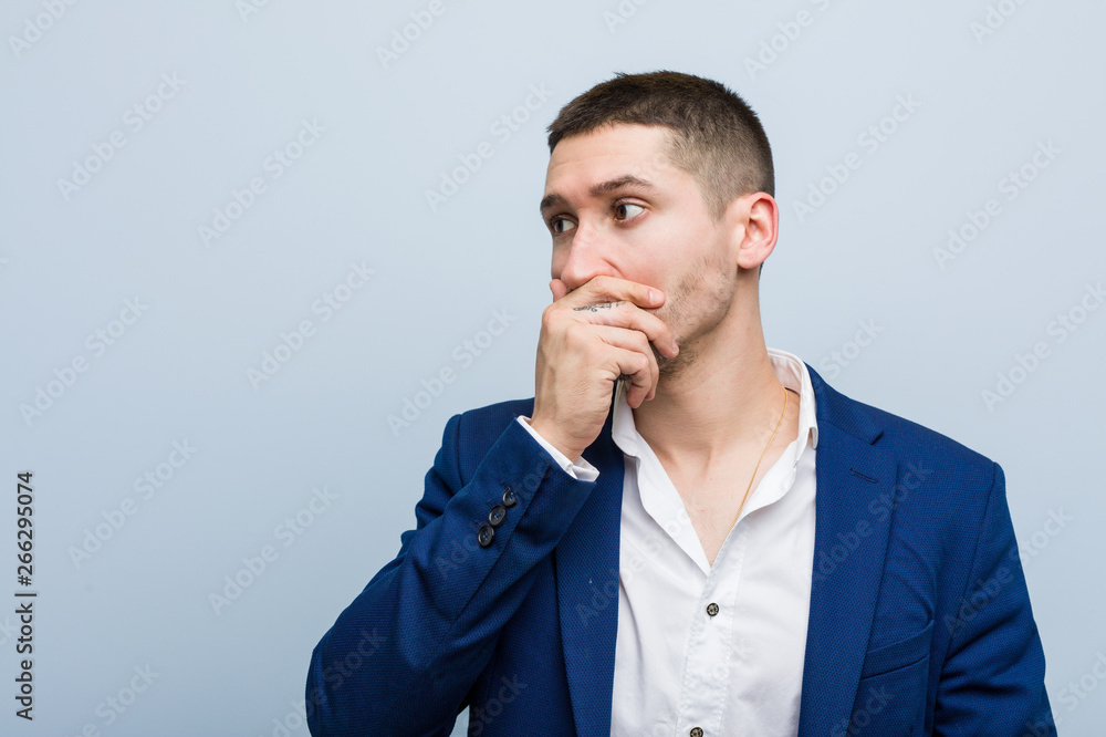Young business caucasian man thoughtful looking to a copy space covering mouth with hand. Young business caucasian man thoughtful looking to a copy space covering mouth with hand.